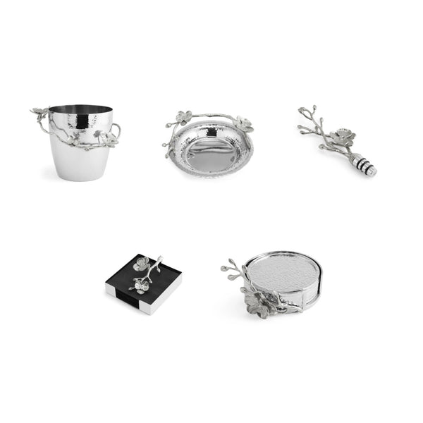 Five Michael Aram White Orchid Barware pieces—bucket, tray, bottle stopper, box, and shallow dish—feature floral and branch accents by Michael Aram and are displayed on a white background.
