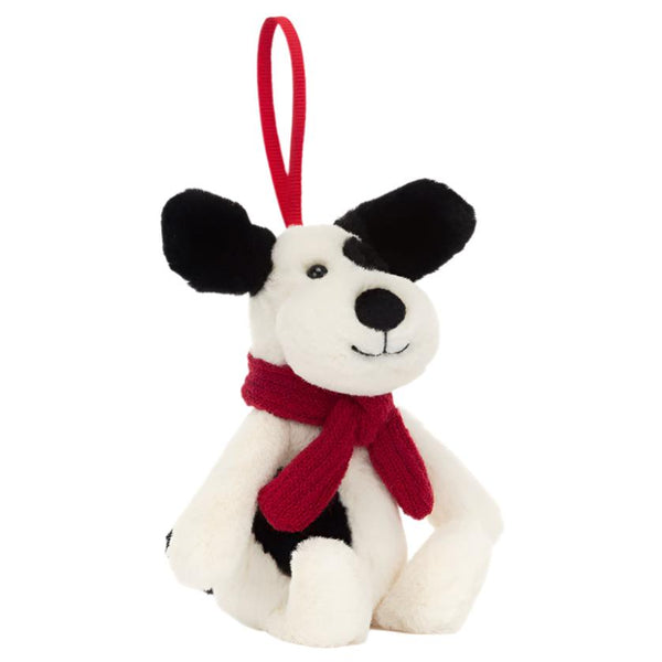 The Jellycat Bashful Puppy Ornament from Jellycat features charming black and white fur and is adorned with a festive red scarf. Designed as a delightful Christmas decoration, it sits upright and includes a loop for easy hanging.