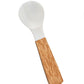The Be Home Shell and Bamboo Serving Collection features a white plastic spoon with a wide bowl and a natural-grain bamboo handle, highlighting organic beauty in every detail.