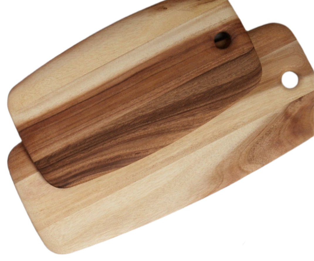 The Be Home Acacia Wood Rectangular Board Collection features two eco-friendly boards with rounded edges and corner holes, crafted from sustainably sourced wood and stacked askew on a white background.