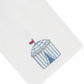 Haute Home’s Beach Cabana Bath Collection premium white linen napkin features an embroidered blue and white striped cabana with a red flag on top, beautifully positioned in the lower corner.