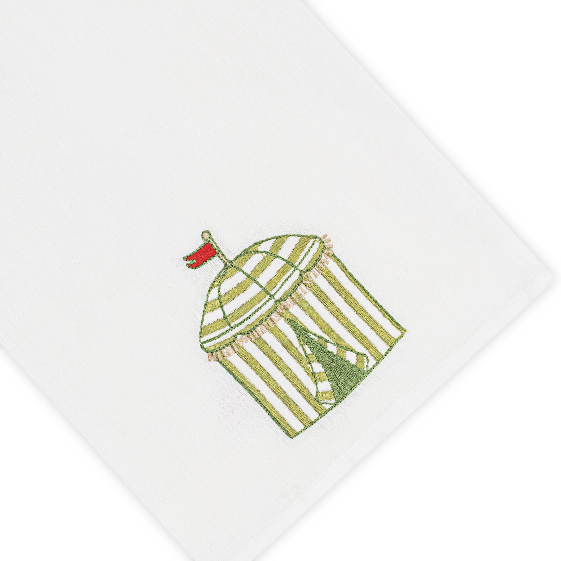 Haute Home’s Beach Cabana Bath Collection linen napkin features a white Italian linen fabric embroidered with a green and white striped cabana topped by a red flag.