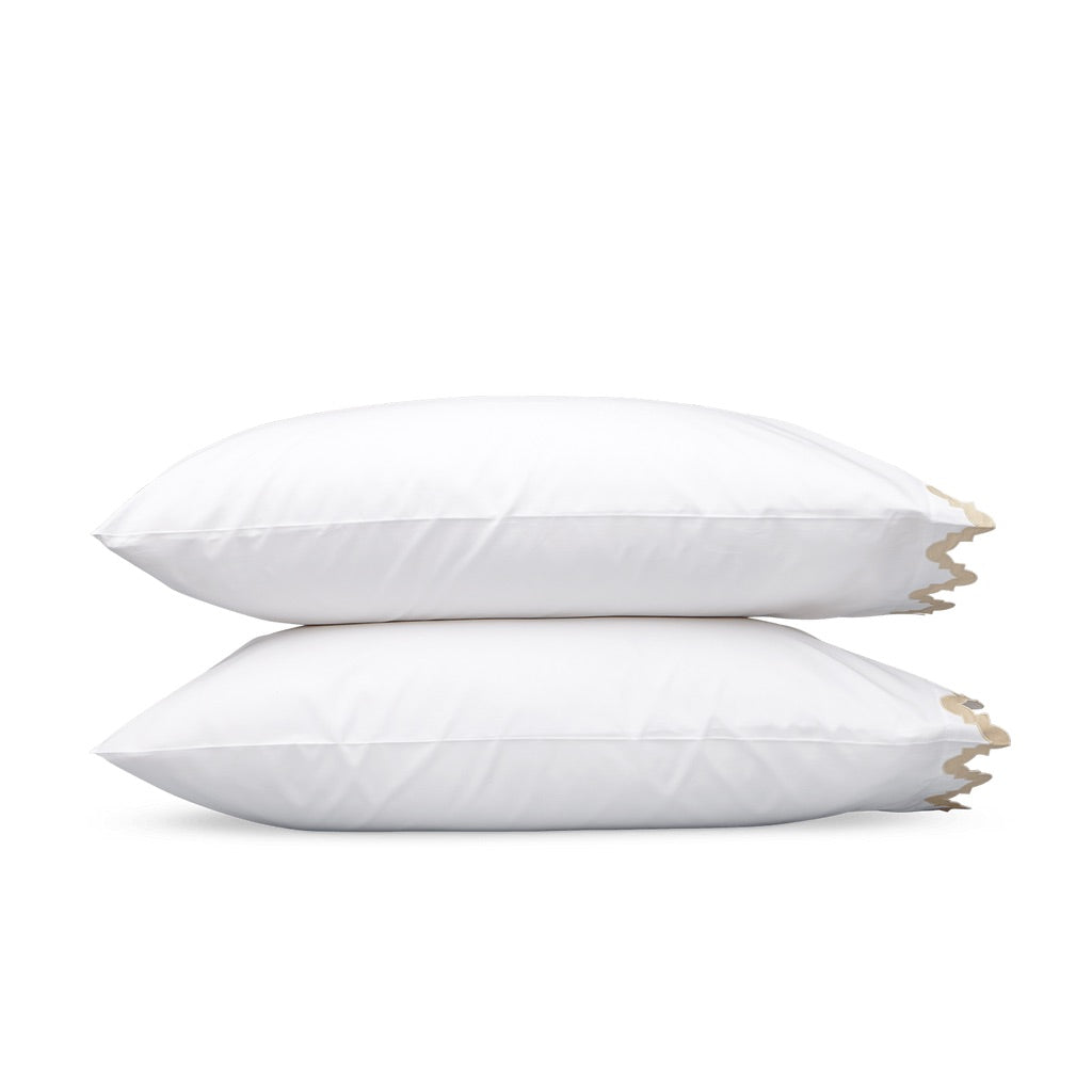 Two white Egyptian cotton pillows from the Matouk Aziza Bedding Collection, Champagne, stacked vertically with a tan scalloped edge detail on the right side.