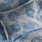 The Matouk Tillett x Matouk Chrysanthemum Bedding Collection in Blue features a pillow and bedsheet with a blue floral motif on a white background.