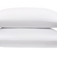 Two white pillows from the Matouk Bergamo Hemstitch Bedding Collection stacked against a white background, crafted from luxurious Egyptian cotton percale and OEKO-TEX certified for quality and comfort.