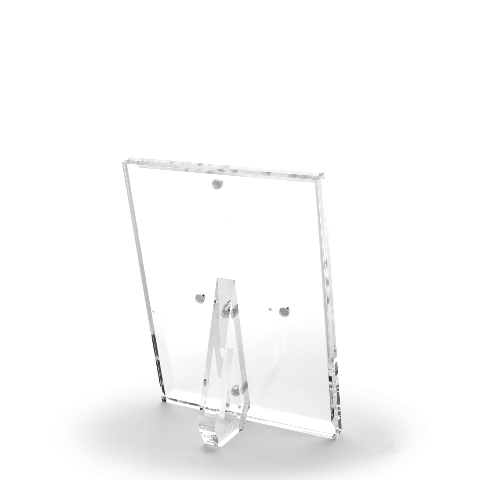 The Clear Beveled Frame Collection by Tara Wilson Designs features a clear lucite frame with a beveled face and stand, displayed from the back on a white background.