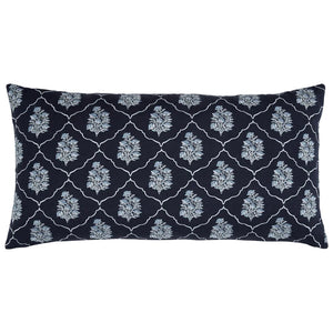The Vinit Bolster Pillow by John Robshaw is a rectangular navy blue pillow embroidered with a repeating white floral and lattice pattern, inspired by the elegance of a Mughal garden.