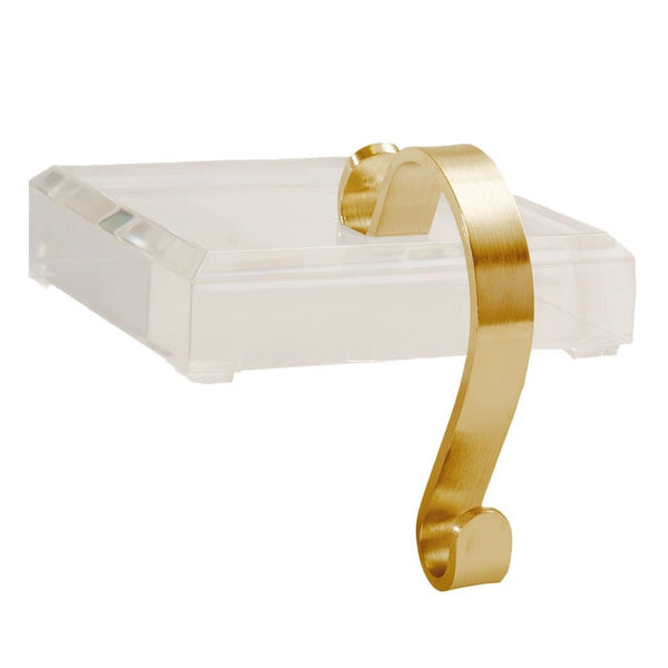 The Fig and Dove Brass & Acrylic Stocking Holder features a stylish adjustable metal hook on a clear acrylic block, all showcased against a pristine white backdrop.