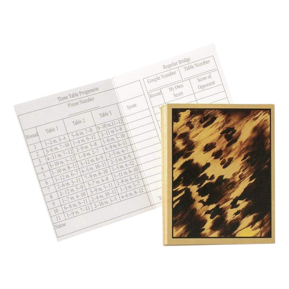 Caspari's Tortoise Bridge Tallies include tally cards, tables, and a pen placed atop a closed, patterned scorebook—perfect for tracking your progressive bridge games.