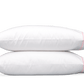 Two white pillows from the Matouk Butterfield Bedding Collection, Azalea, crafted from Egyptian cotton percale with a 500 thread count, are stacked against a plain background.