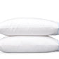 Two white pillows from the Butterfield Bedding Collection by Matouk, featuring elegant blue piping and a subtle scallop detail, are stacked together against a plain white background—an ideal complement to Egyptian cotton or crisp percale sheeting.