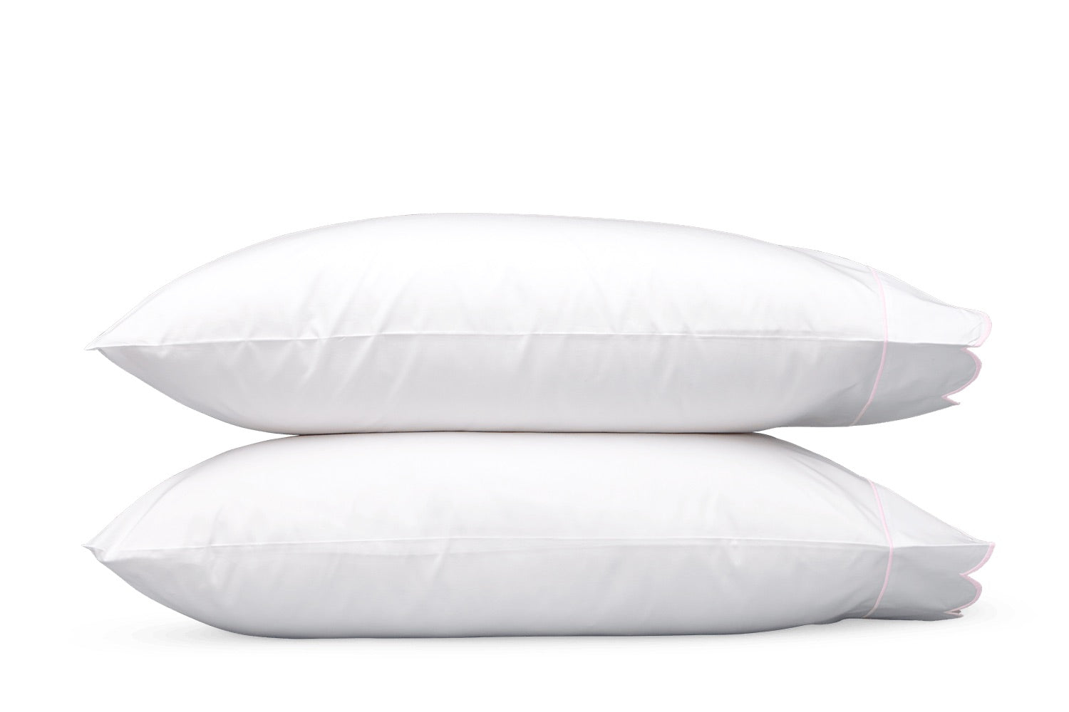 Two white pillows from the Matouk Butterfield Bedding Collection, featuring elegant scallop detailing, are stacked on top of each other against a plain white background.