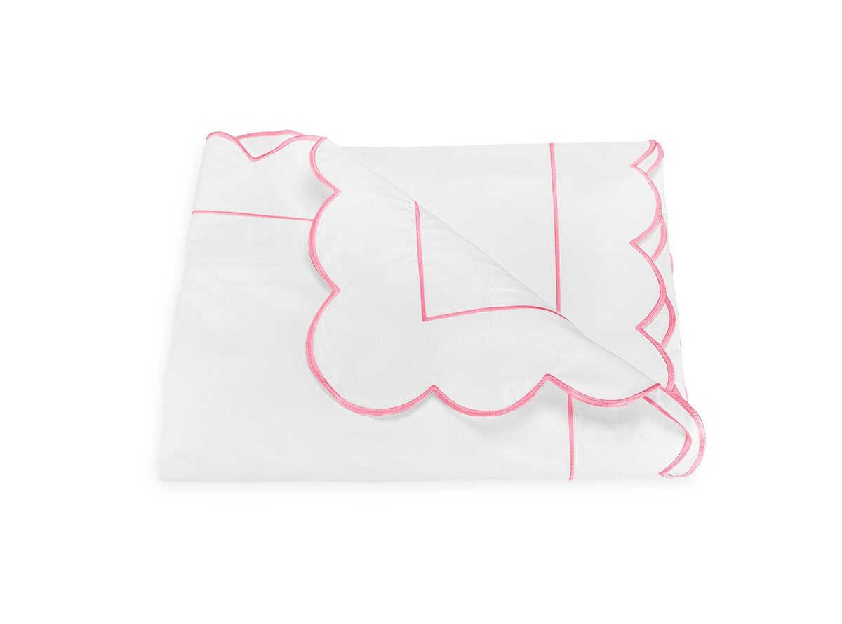 Butterfield Bedding Collection blanket by Matouk, featuring white fabric with pink scallop detailing along the trim and border, displayed against a plain white background.