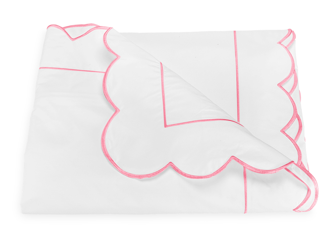 The Butterfield Bedding Collection, Azalea by Matouk features a white folded blanket with pink scallop detail and line accents, crafted from 500 thread count Egyptian cotton percale, shown on a plain white background.