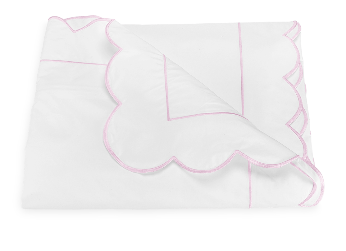 The Butterfield Bedding Collection in Pink by Matouk features a white blanket with pink scallop details and line accents, crafted from luxurious 500 thread count Egyptian cotton percale, shown folded and partially turned down on a plain background.