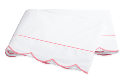 The Butterfield Bedding Collection, Azalea by Matouk features a folded white Egyptian cotton percale bedsheet with scalloped edges and a single pink line of trim.