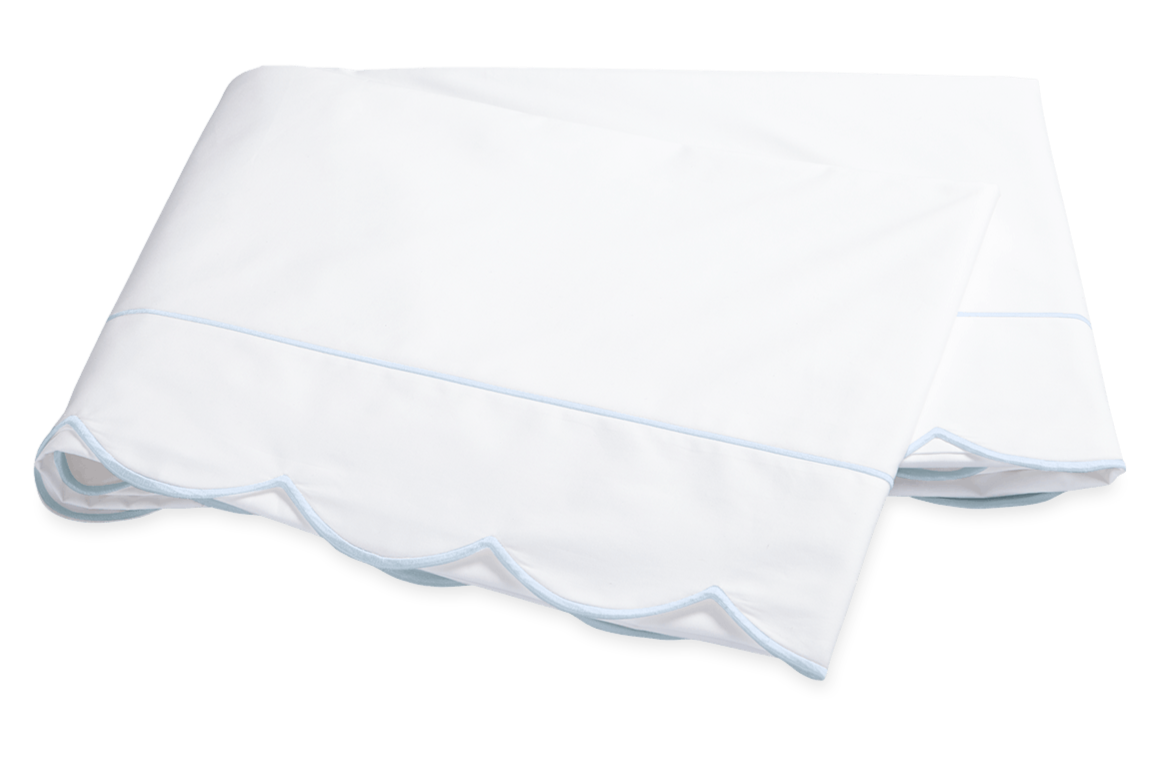 Two folded white bedsheets from the Matouk Butterfield Bedding Collection, Blue, feature elegant scallop detailing and blue-edged trim, crafted from luxurious Egyptian cotton percale.