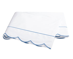 The Butterfield Bedding Collection by Matouk features a white folded bedsheet with elegant scallop detailing and light blue trim, crafted from luxurious Egyptian cotton and displayed on a plain white background.