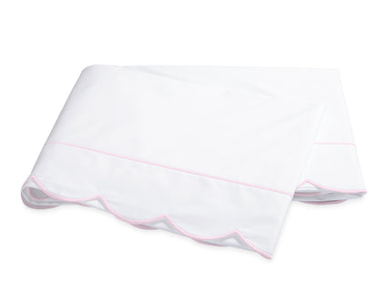Folded white percale sheeting from the Matouk Butterfield Bedding Collection, featuring a scalloped pink trim along one edge, displayed on a plain white background.