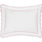 The Butterfield Bedding Collection by Matouk features a white rectangular pillow with scallop detailing along the edge and a thin pink border, designed to complement Egyptian cotton sheets; displayed on a plain white background.