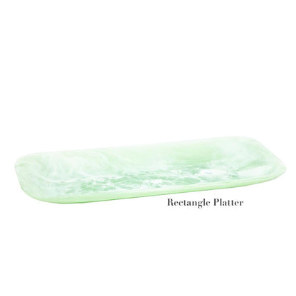 A rectangular, light green marbled resin platter from the Mint Resin Serveware Collection by Nashi Home, featuring slightly raised edges and a shatter-resistant design. Displayed on white with "Rectangle Platter" below. Ideal for stylish home decor.