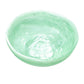 The Mint Resin Serveware Collection by Nashi Home features a light green, shallow bowl with a marbled finish—ideal as a stylish serving piece or decorative accent for your home, shown against a white background.
