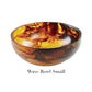 The Tortoise Resin Serveware Collection by Nashi Home features a small, round bowl with a marbled amber and brown pattern. Crafted from shatter-resistant resinware, this stylish Wave Bowl Small is perfect for home decor accents.