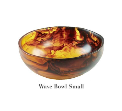 The Tortoise Resin Serveware Collection by Nashi Home features a small, round bowl with a marbled amber and brown pattern. Crafted from shatter-resistant resinware, this stylish Wave Bowl Small is perfect for home decor accents.