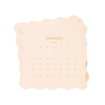A stack of peach-colored Sugar Paper 2027 Desk Calendar pages with scalloped edges showing the month of January.