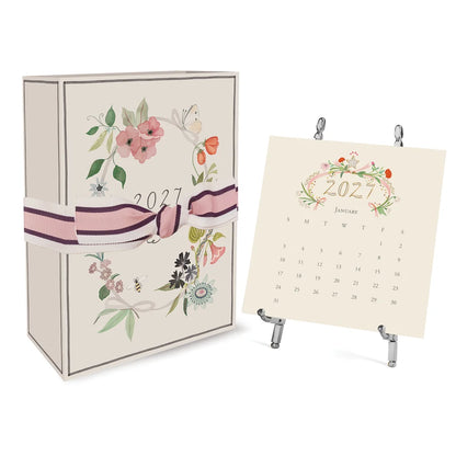 A floral-themed 2027 Classic Desk Calendar with Silver Easel by Karen Adams displayed in its gift box on a silver metal easel.
