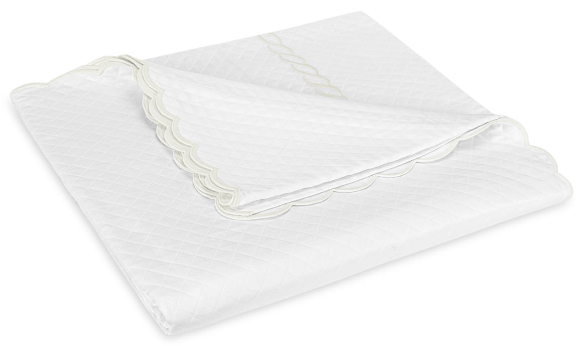 The Matouk Classic Chain Scallop Matelassé Bedding Collection in white, featuring a diamond matelassé pattern and decorative scalloped edge, exudes timeless elegance.