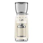 The Smeg Coffee Grinder, from the SMEG Coffee Grinder Collection, in cream, features a clear hopper and container with a shiny metallic side knob for perfect grind adjustments.