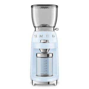 A light blue SMEG Coffee Grinder from Smeg's retro-style collection features a transparent hopper and a glass container for the perfect grind every time.