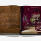 An open book titled "Relaxed Luxury" by Assouline features a quote on the left page and a photo of a Chad Dorsey-designed, red-toned home bar with chandeliers and wooden floors on the right.