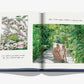 An open book features a woman and child with a toy dinosaur in a lush garden, embodying Cheval Blanc's bespoke service. The adjacent page shows shells with handwritten notes beneath, capturing Assouline's luxury hospitality essence in every detail.