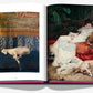 An open book, "Chic Dogs" by Assouline, displays a stylish scene: the left page features a dog lounging elegantly on a patterned couch, while the right showcases a luxurious painting of a woman with her relaxed companion.
