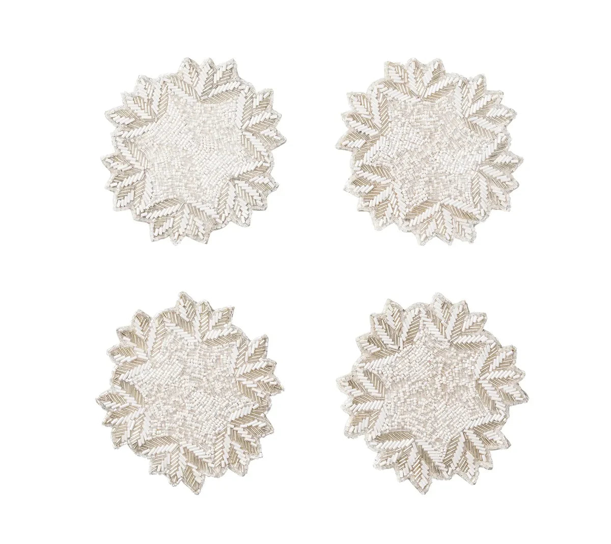 Four circular, beaded Winter Lace Coasters featuring a white and silver snowflake pattern.