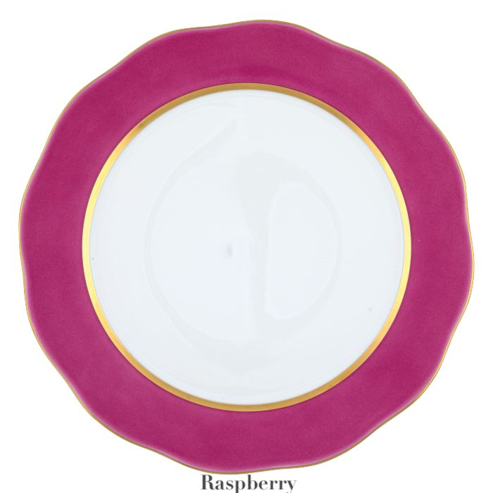 The Herend Silk Ribbons Charger is a handmade porcelain plate featuring a wavy, raspberry-colored rim and gold inner border—perfect for elevating any tabletop. "Raspberry" is written below.