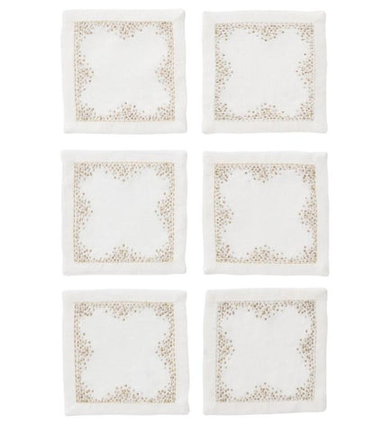 The Kim Seybert Pin Dot Cocktail Napkin Set features six white linen napkins with beige embroidered borders, arranged in two rows of three on a white background—perfect for adding elegance to your table setting.