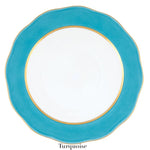 The Herend Silk Ribbons Charger features a round white plate with a turquoise blue scalloped edge and gold rim, adding elegance to any table. The word "Turquoise" appears below the plate.