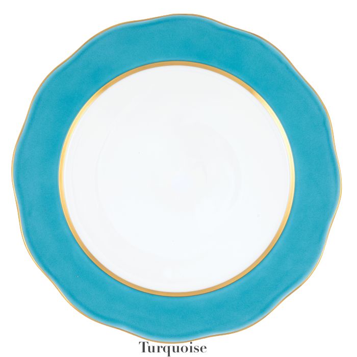The Herend Silk Ribbons Charger features a round white plate with a turquoise blue scalloped edge and gold rim, adding elegance to any table. The word "Turquoise" appears below the plate.