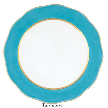 The Herend Silk Ribbons Charger features a round white plate with a turquoise blue scalloped edge and gold rim, adding elegance to any table. The word "Turquoise" appears below the plate.