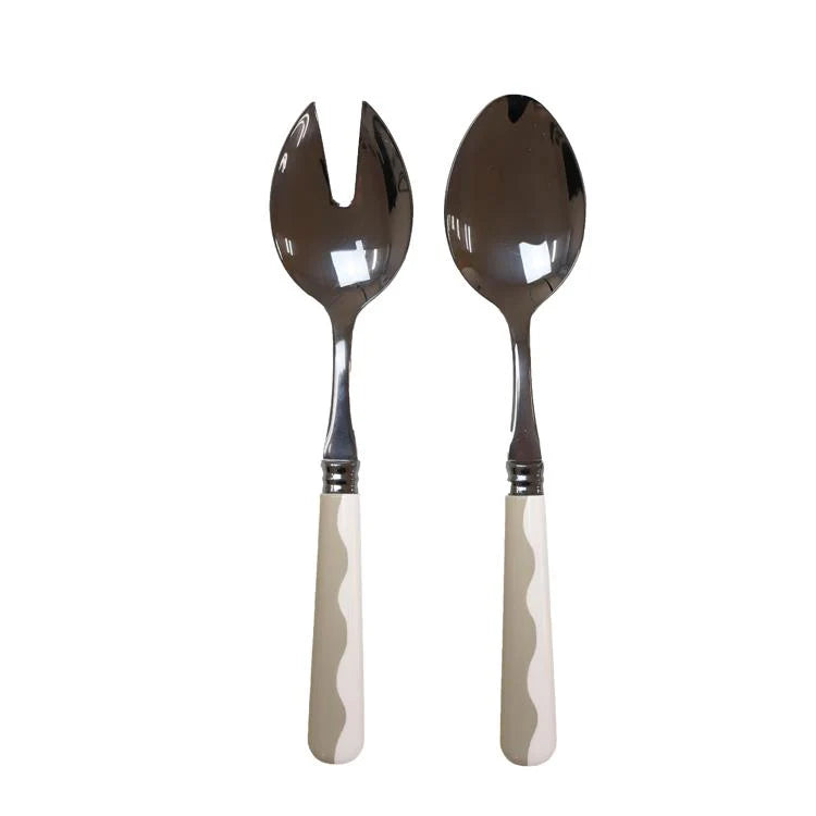 The Addison Ross Wave Salad Server Set features a serving spoon and slotted fork with stainless steel heads and white wavy handles, adding elegance to any table setting.