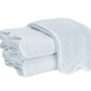 A neatly folded stack of light blue Matouk Cairo Scallop Bath Collection luxury towels with white trim, displayed on a plain white background.
