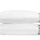 Two white pillows from the Callista Bedding Collection by Matouk are stacked together, each crafted from luxurious Giza Egyptian cotton with a 500 thread count, featuring an elegant blue floral design and decorative embroidery along the edge, set against a plain white background.