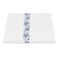 Luxury white bedding from Matouk’s Callista Bedding Collection, featuring a vertical row of blue floral embroidery down the center and crafted from sumptuous Giza Egyptian cotton for a refined, elegant look.