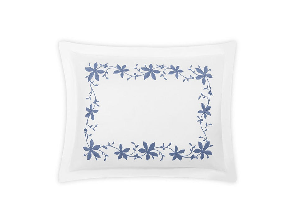 The Matouk Callista Bedding Collection in Bluebell features a white rectangular pillowcase with a blue floral border, crafted from luxurious Giza Egyptian cotton and finished with decorative embroidery.