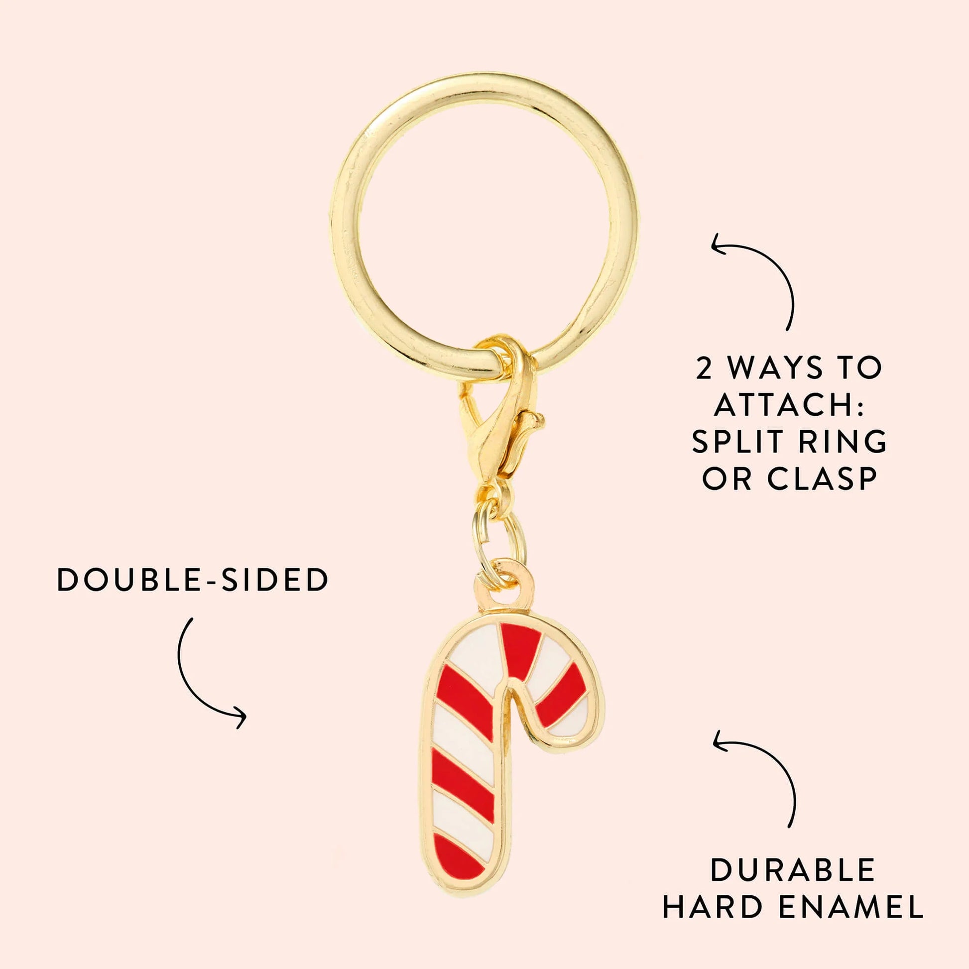 The Foggy Dog Candy Cane Collar Charm is a gold keychain featuring a double-sided red and white candy cane, with a split ring and clasp attachment. Made of durable hard enamel, this festive accessory is perfect for collars.