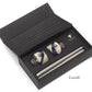 A black box features the Baobab Collection Candle Holder Twins, showcasing a pair of ceramic stoppers with a blue and white design and an elegant metal wine pourer. The lid is adorned with the brand's logo and text. Ideal for decorative object enthusiasts, this set enhances any collection or occasion with its charm.