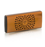 The Baobab Collection Car Diffuser by Baobab is a rectangular, orange-brown fragrance accessory with black circular holes on the front and black end panels, shown resting on a reflective surface.